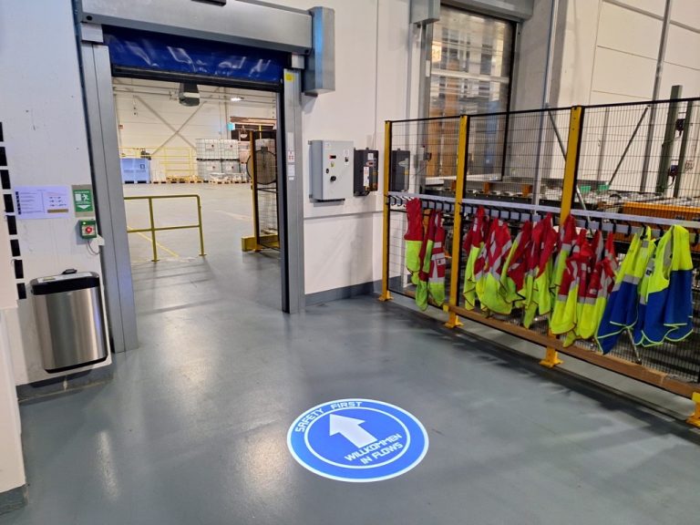 Projektion eines Wegweisers auf den Fußboden einer Fabrikhalle