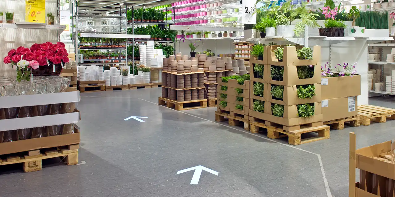 Projektion eines Pfeils auf dem Boden im IKEA Essen zur Orientierung der Kunden.